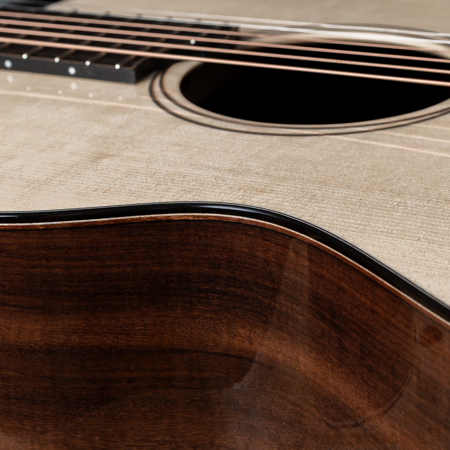 Close-up of an acoustic guitar's soundhole and wooden body