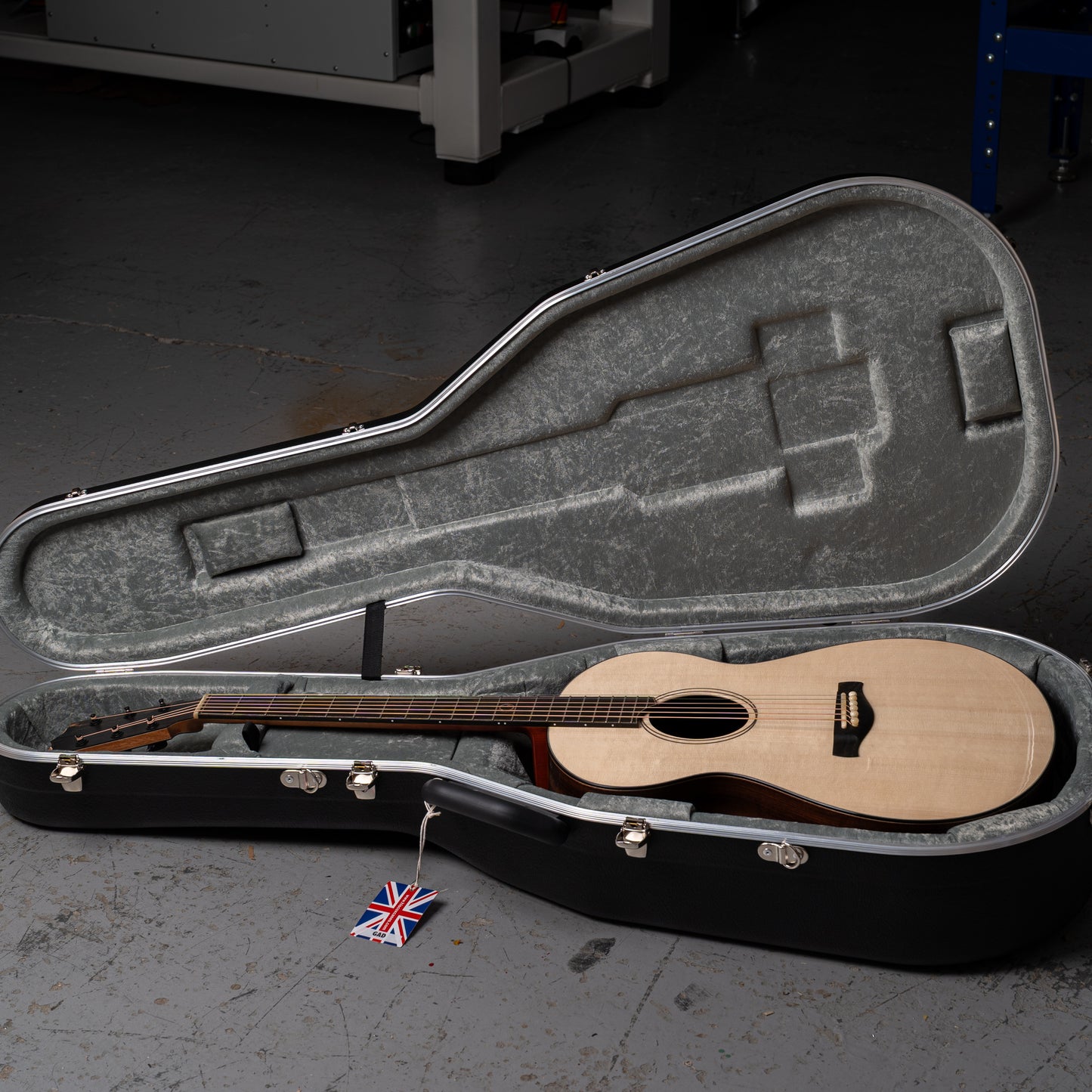 Acoustic guitar in a hard case on a dark floor
